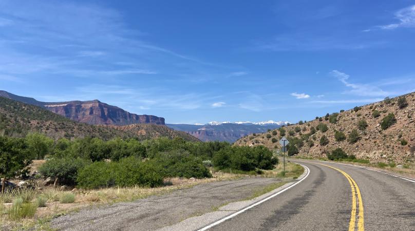 Picture Road Going Around a Bend With Mountains in the Background