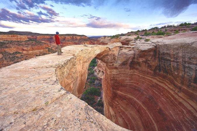 Man Standing on Arch in Rattlesnake Arches