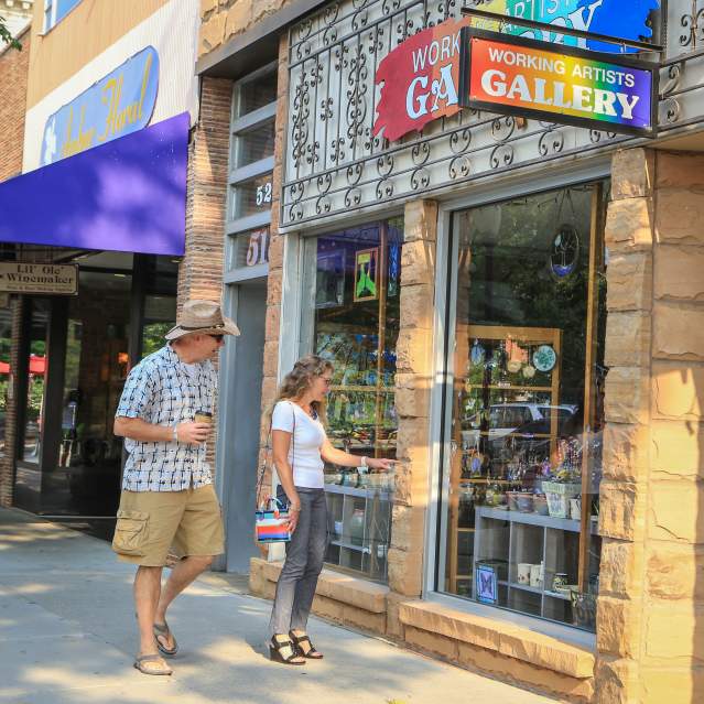Couple walks down Main Street looking in the windows of local businesses