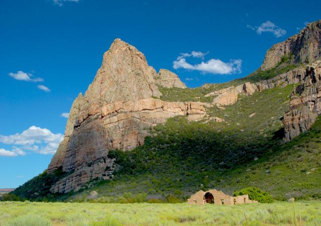 Picture of Mountain with a Small Building in Front of It