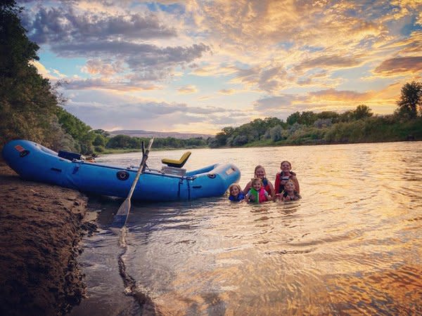 Kids swimming next to Raft in the Colorado River