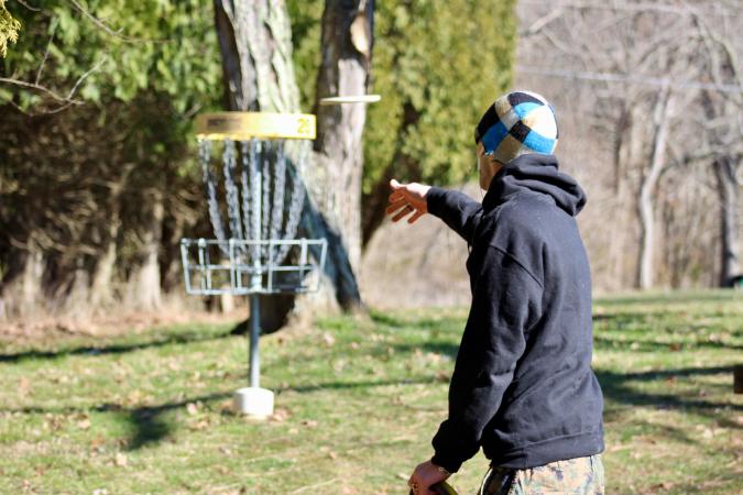 Person Putting a Disc in Disc Golf
