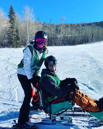One Skier in Adaptive Skiing Equipment and Another Skier Posing for the Photo