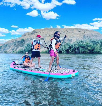 Two Men and one Woman on a Large SUP on the River