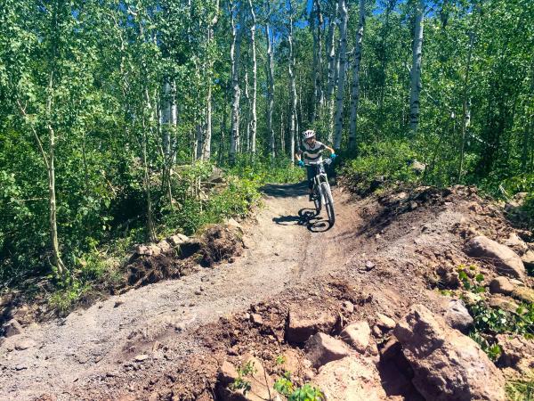 Kid Mountain Biking down trail at Powderhorn Mountain Resort