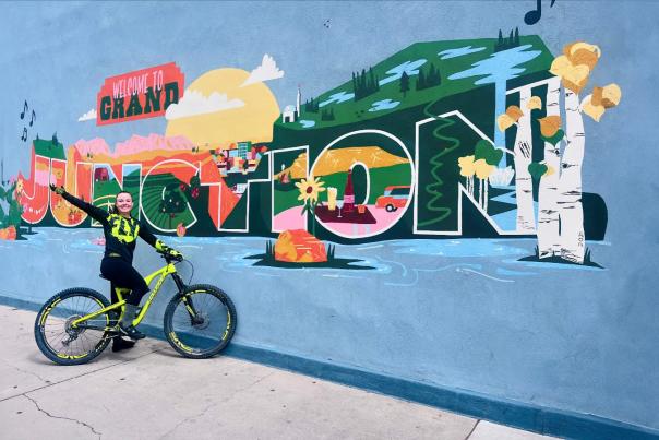 Girl on Mountain Bike Standing in Front of Grand Junction Mural in Downtown GJ