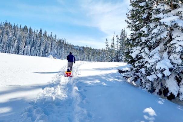 Dad Pulling Child in Sled on the Grand Mesa