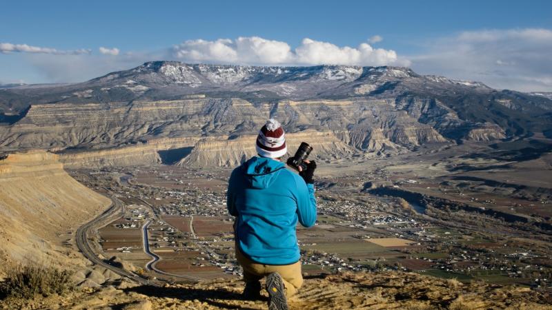 Man holding camera overlooking the Grand Junction Area
