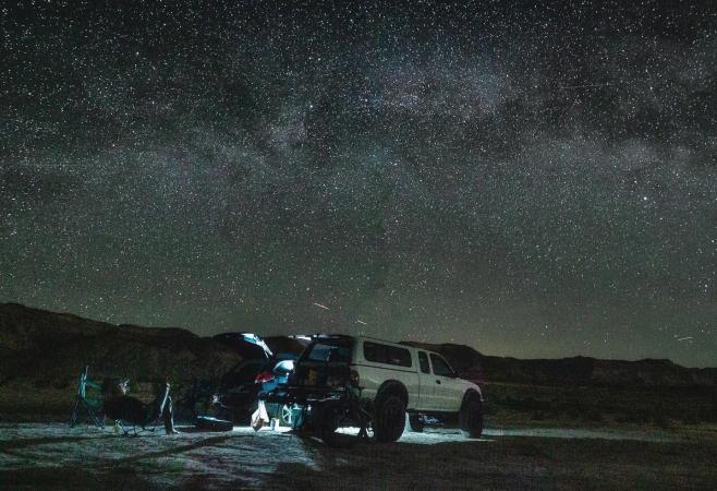 People sitting in camp chairs under the stars