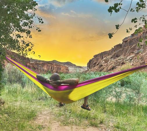 Man Sitting in a Hammock looking at sunset